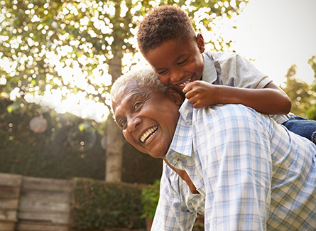 Grandfather with grandson playing in yard