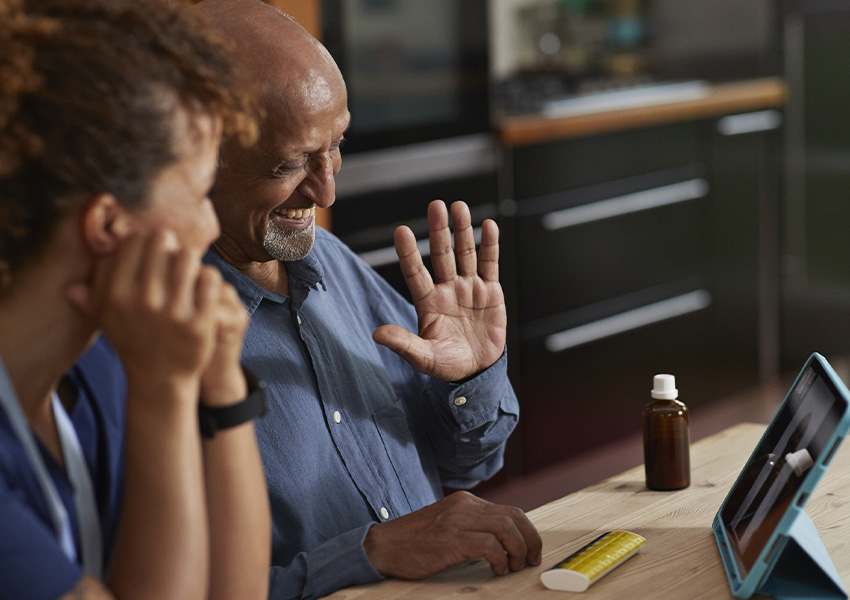 An older man speaking via tablet with his doctor