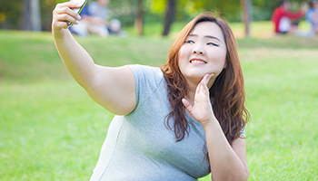 A woman taking a selfie in the park