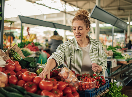 Young woman picking out produce at Farmers Market