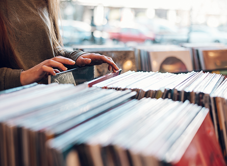 Woman shorting through vinyl records at shop