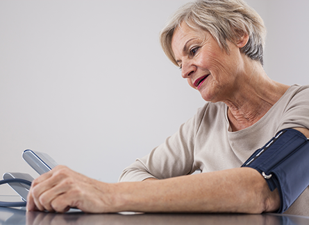 Woman using a blood pressure machine at home