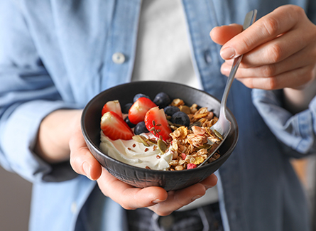 Woman eating a bowl of yogurt