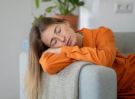 Tired woman napping on couch