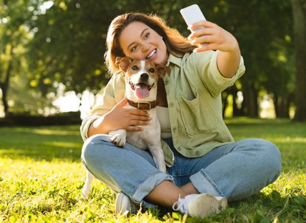 Woman in park taking selfie with dog